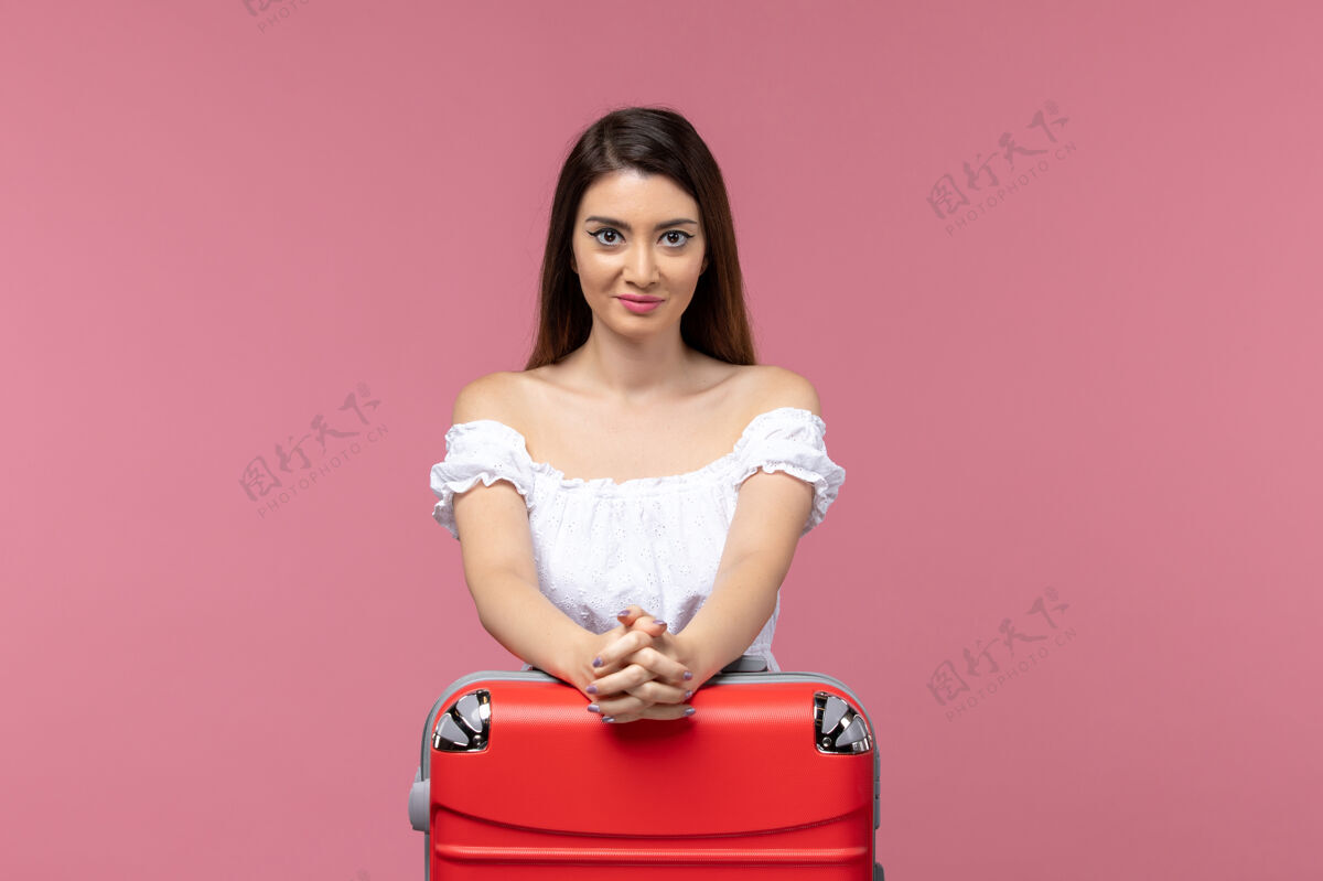 人正面图：年轻女子带着她的红色袋子准备度假 背景是粉色的海上旅行 女子出国度假旅行厕所成人