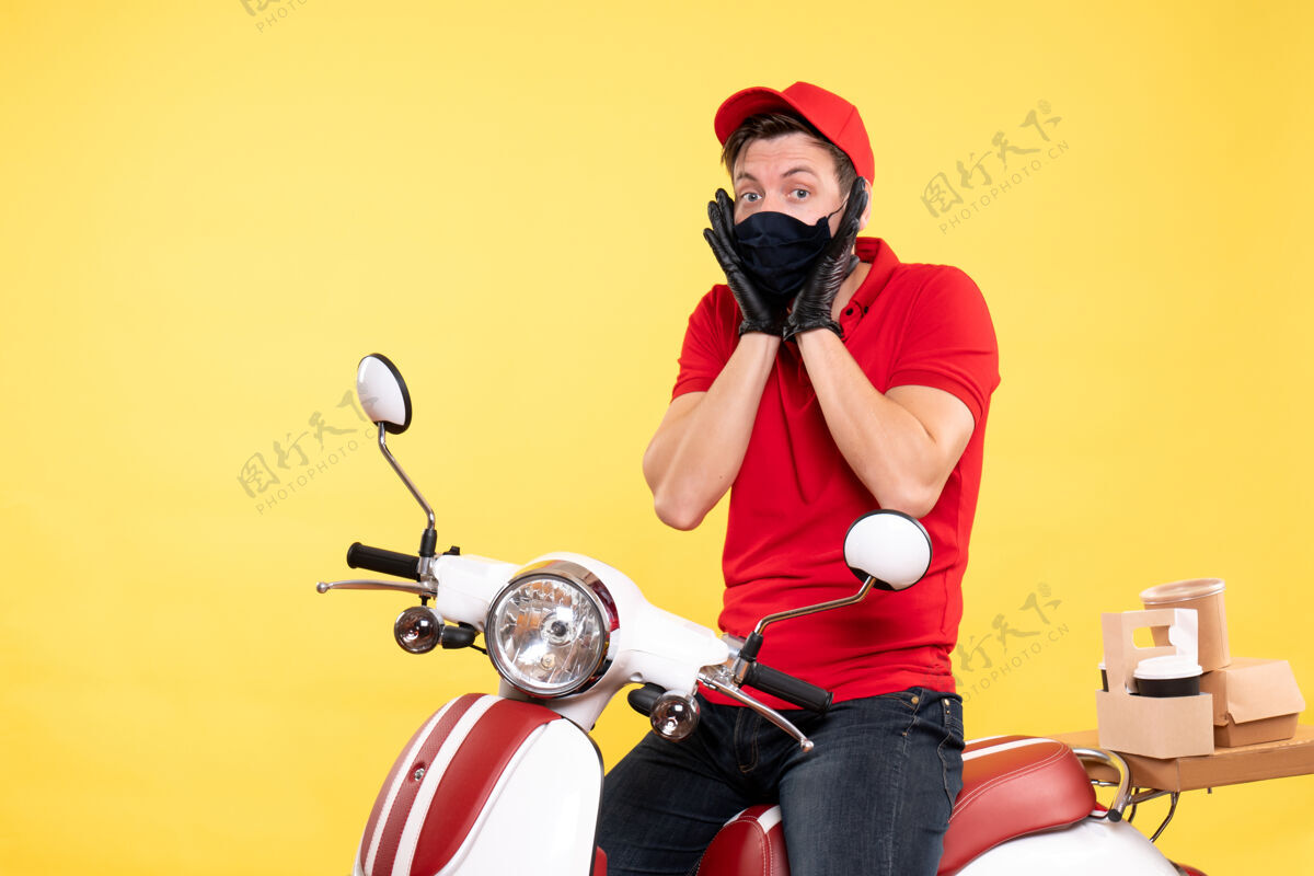 摩托车正面图：穿着红色制服 戴着黄色面具的男信使成人快餐男信使