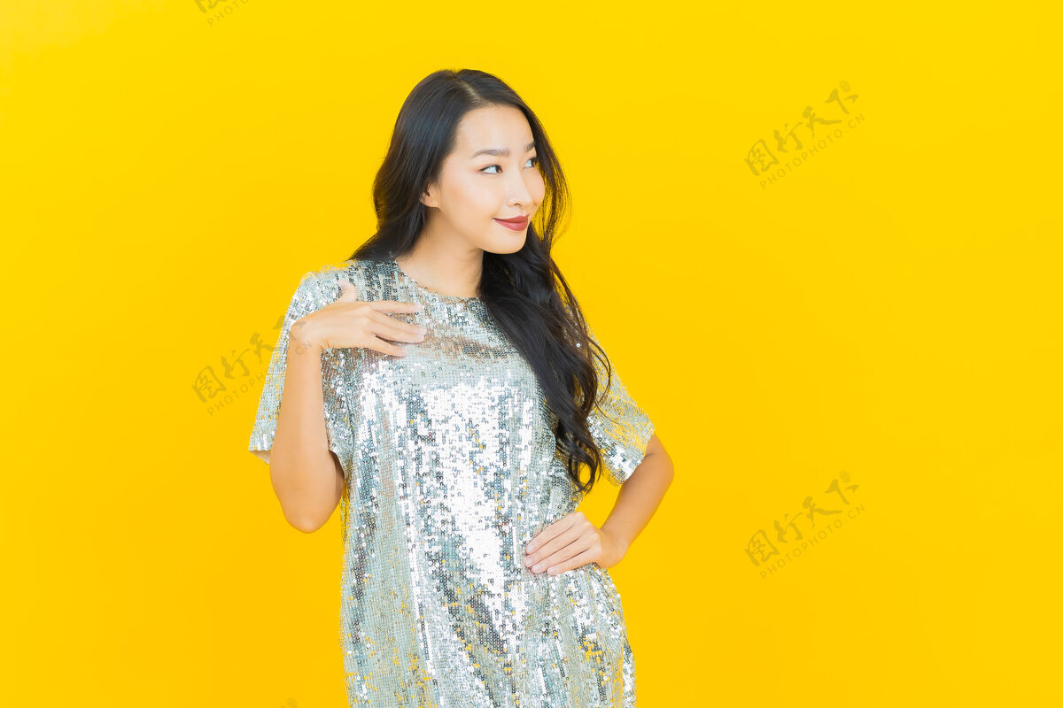 闪亮肖像美丽的亚洲年轻女子微笑着行动黄色女性时尚中国人