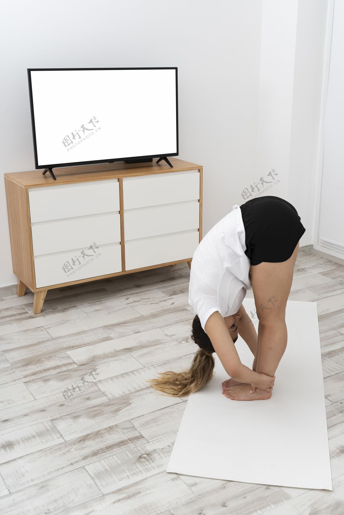 精神运动型女人在家做瑜伽垂直家具女性
