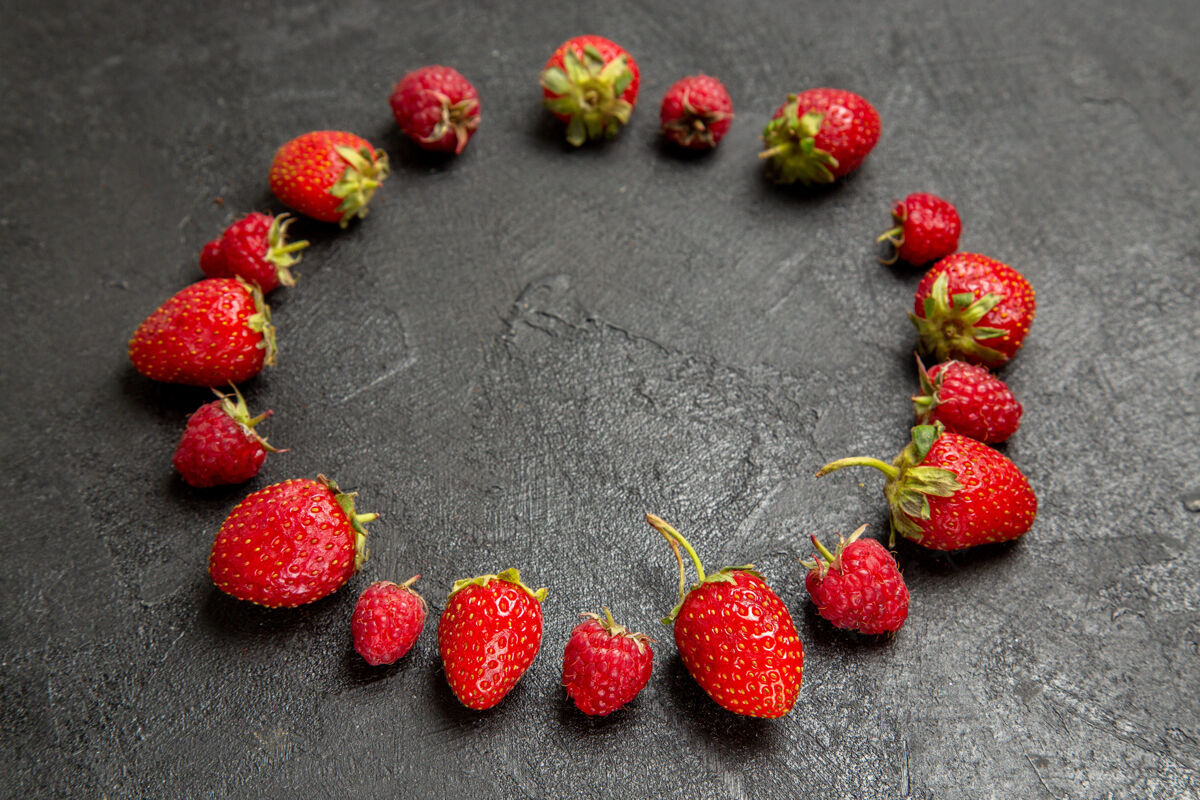 覆盆子前视图新鲜的红色草莓衬在深灰色的背景上食物珠宝甜点