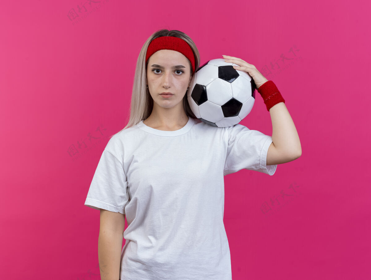 肩膀自信的年轻白人运动女孩戴着背带和头带头带运动腕带