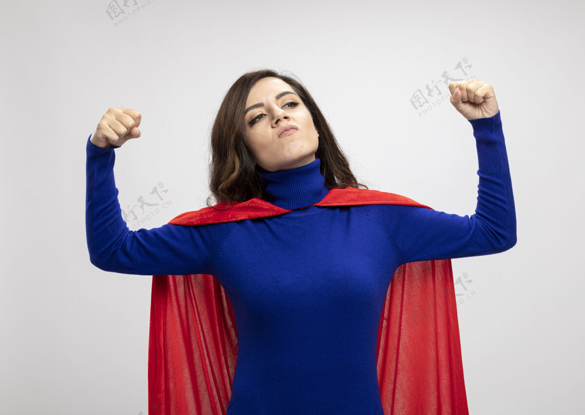 自信自信的白种人超级英雄女孩 穿着红色斗篷 二头肌紧绷 面带白色斗篷壁板紧张