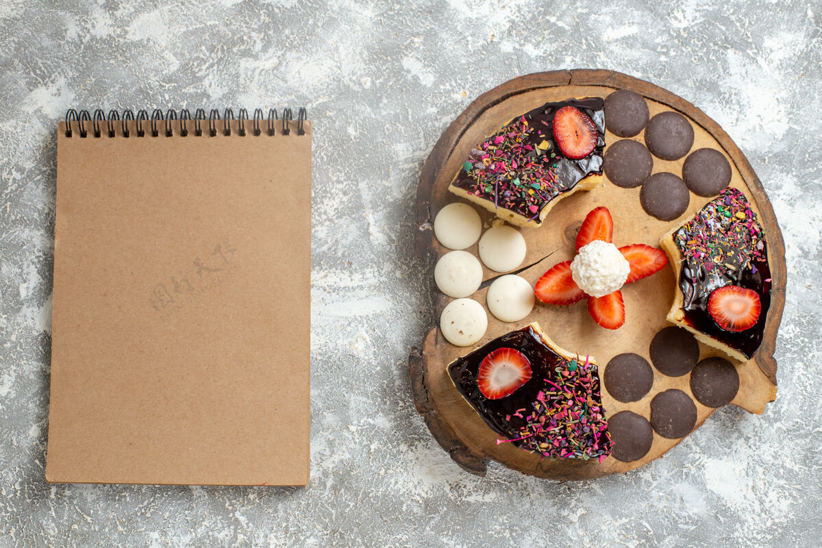 圆形俯瞰美味的蛋糕片和巧克力饼干在白色表面顶部礼品糖果