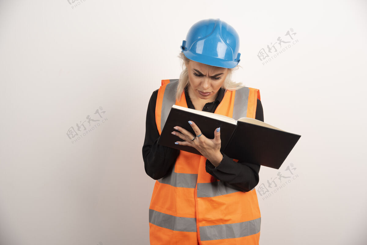 安全帽不高兴的工人检查白色背景上的重要笔记高品质的照片建筑头盔背心