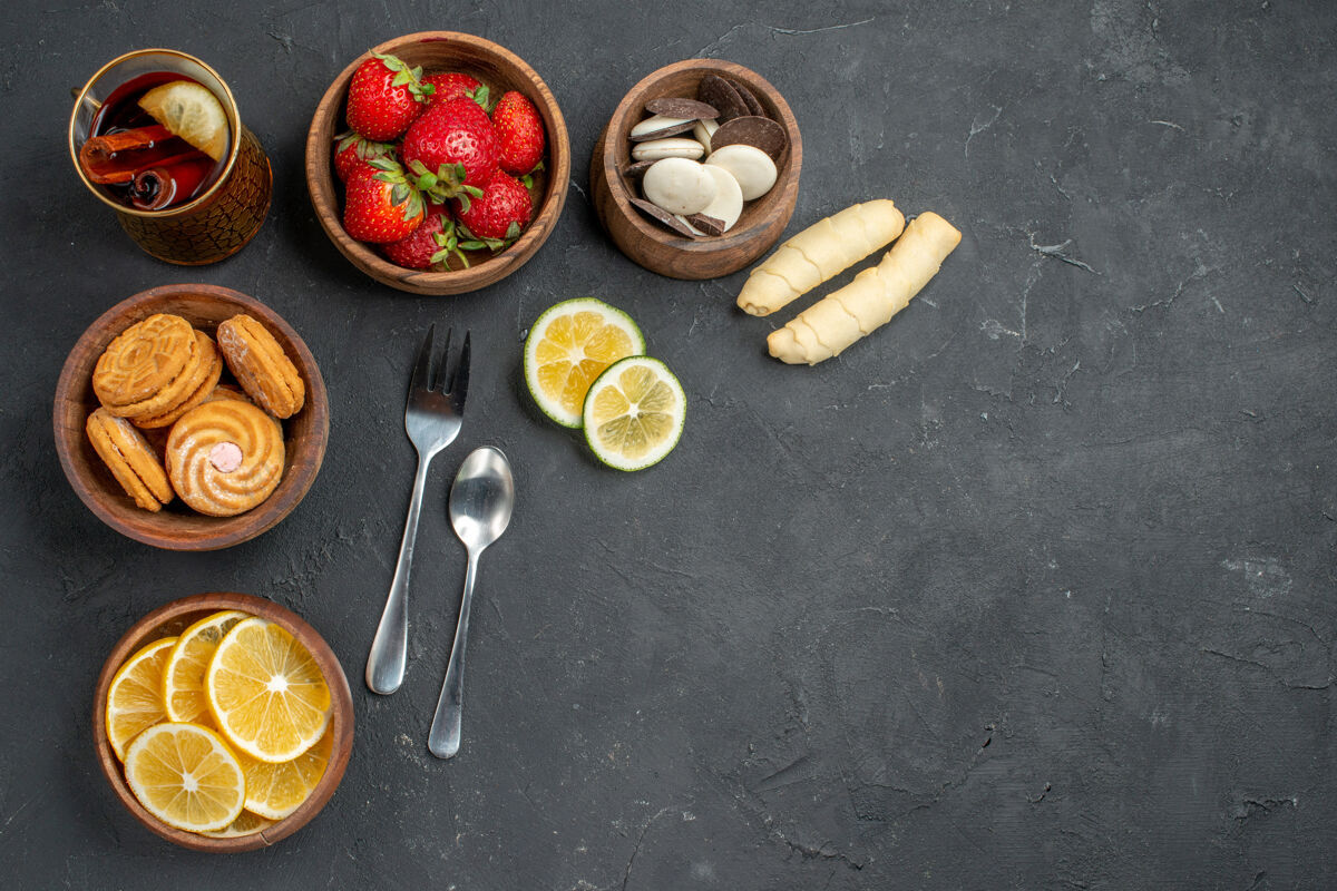 食物顶视图新鲜水果草莓和柠檬与饼干在灰色的表面顶部新鲜水果茶