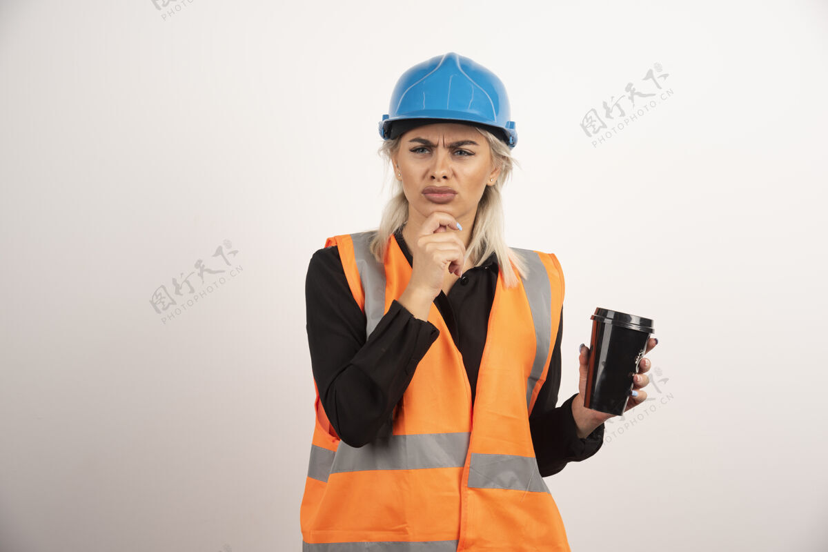 工人建筑工人端着一杯茶在看什么高质量的照片头盔女性女孩