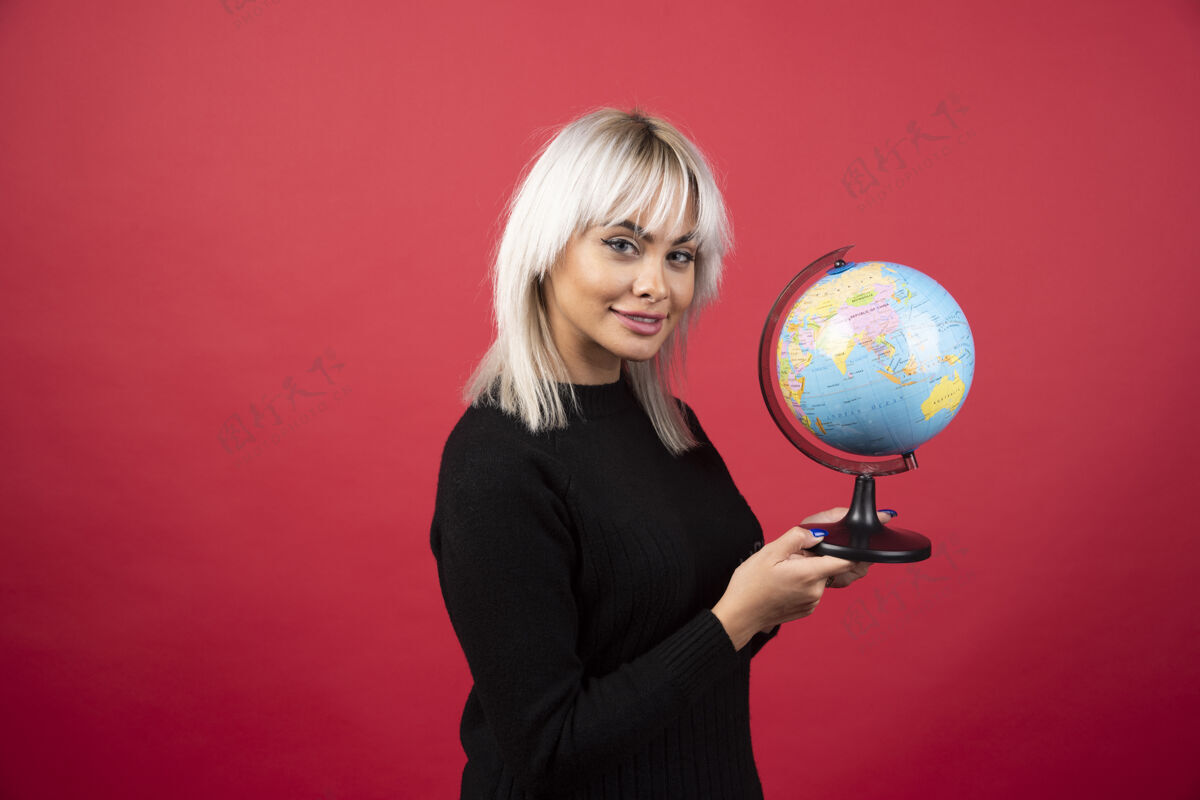 女人在红色背景上与地球仪合影的年轻女子高质量照片肖像女人地球