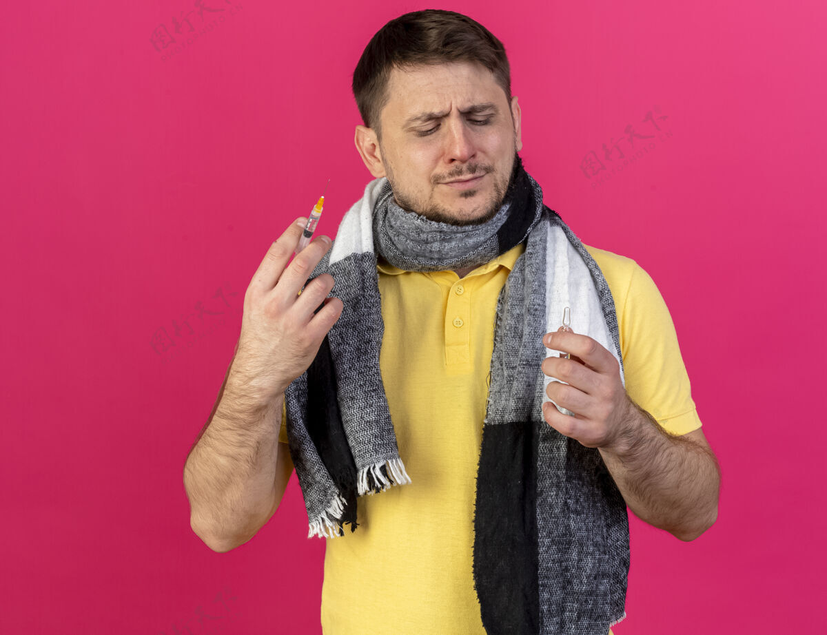 金发年轻的金发病斯拉夫男子戴着围巾拿着注射器和安瓿在粉红色穿粉红男人