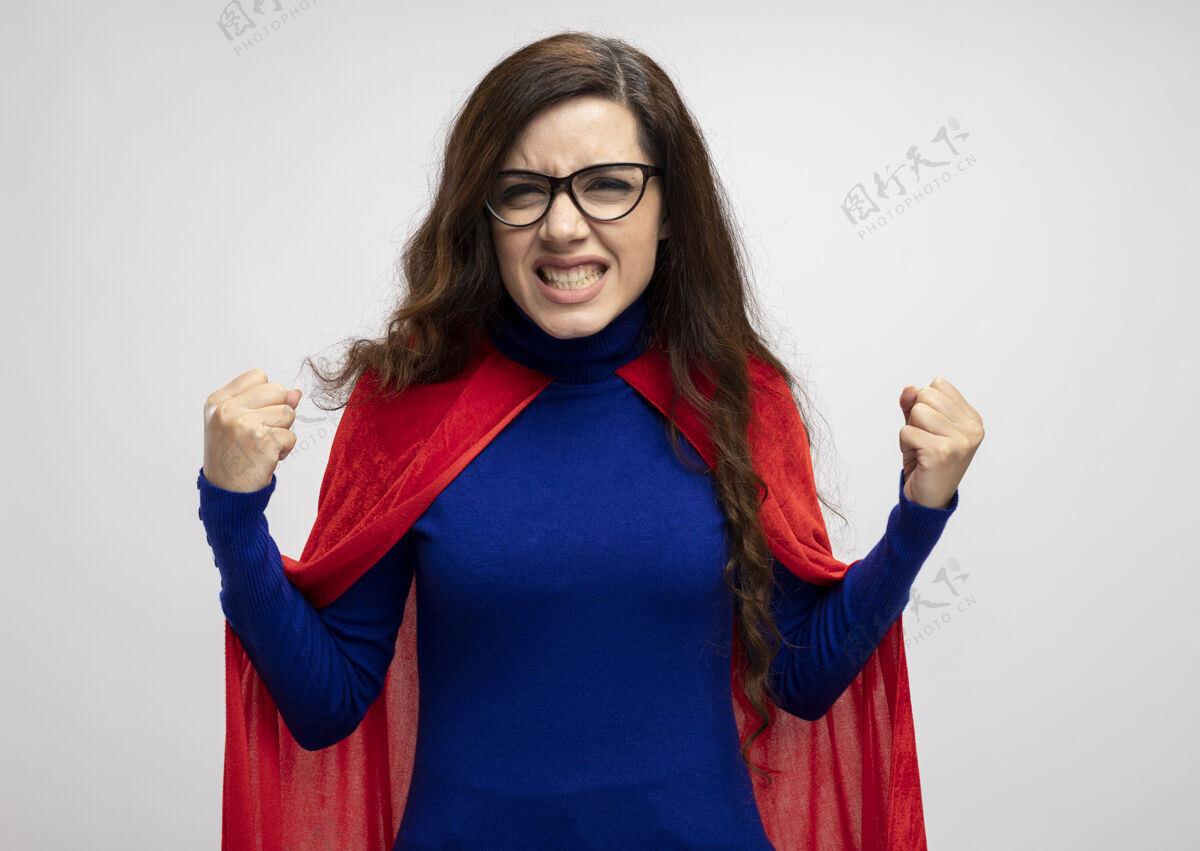 拳头恼怒的高加索超级英雄女孩戴着红斗篷 戴着眼镜 拳头打在白色的脸上光学超级英雄眼镜