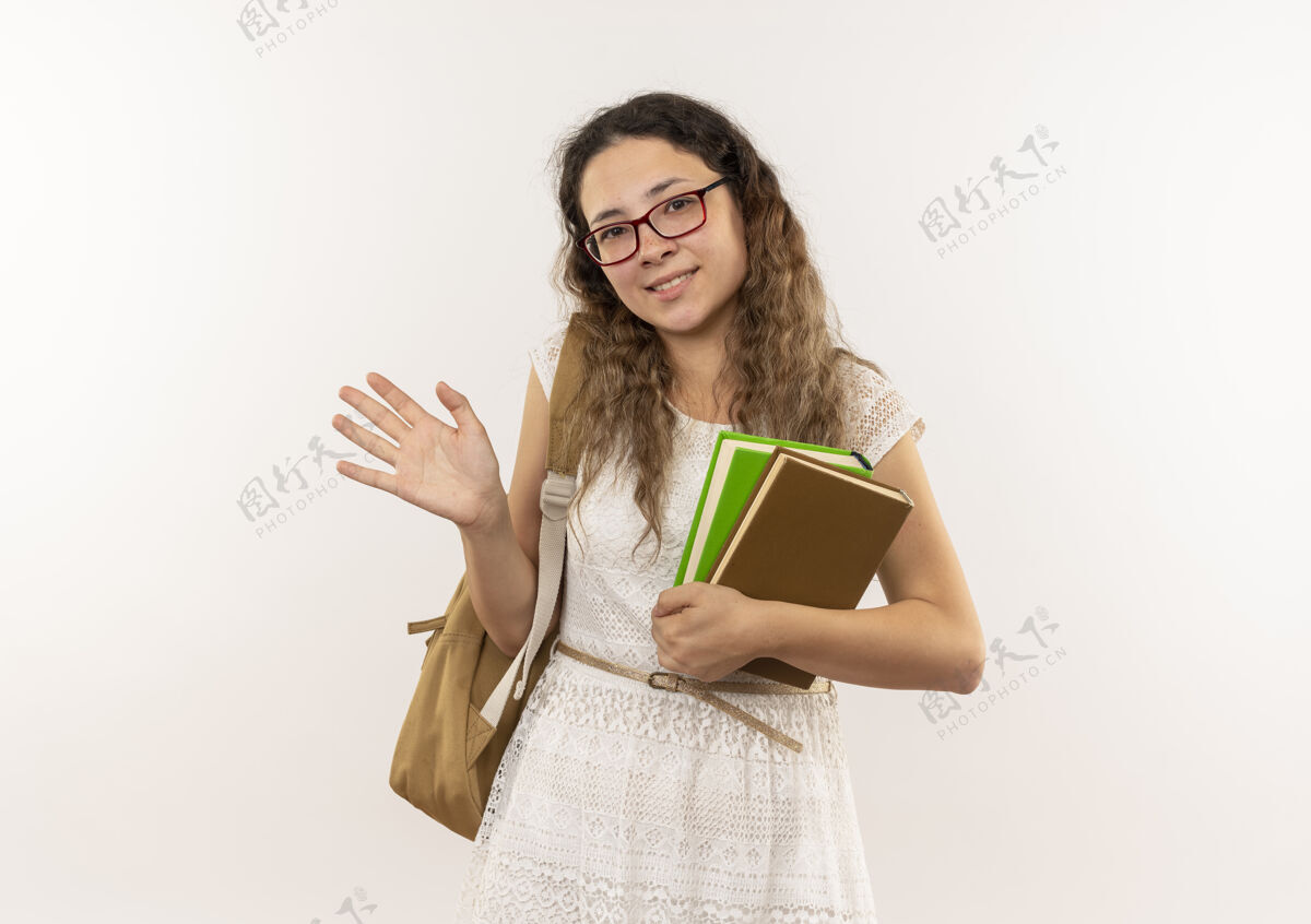 穿着微笑着的年轻漂亮的女学生戴着眼镜 背着书包 在白色的墙上打着手势人衣服表情