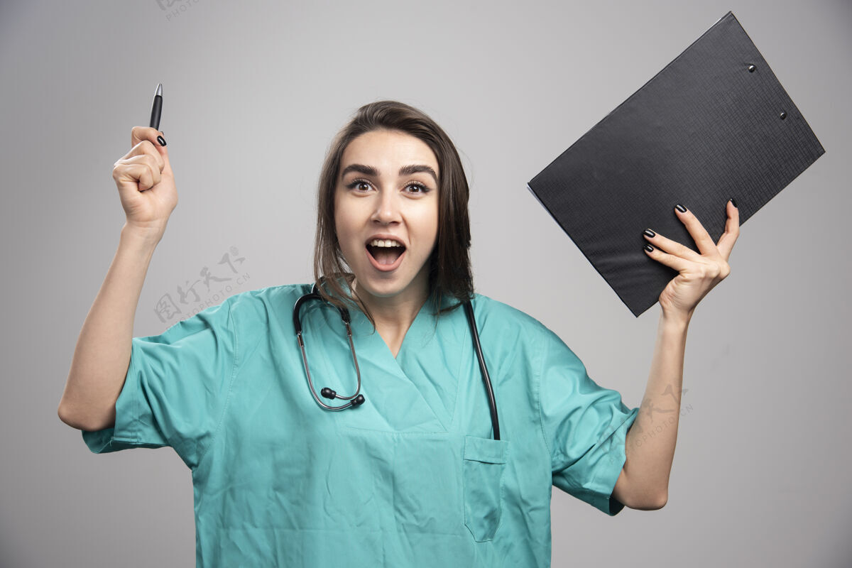 女性穿着制服的女医生拿着剪贴板大笑高质量的照片医生疾病健康