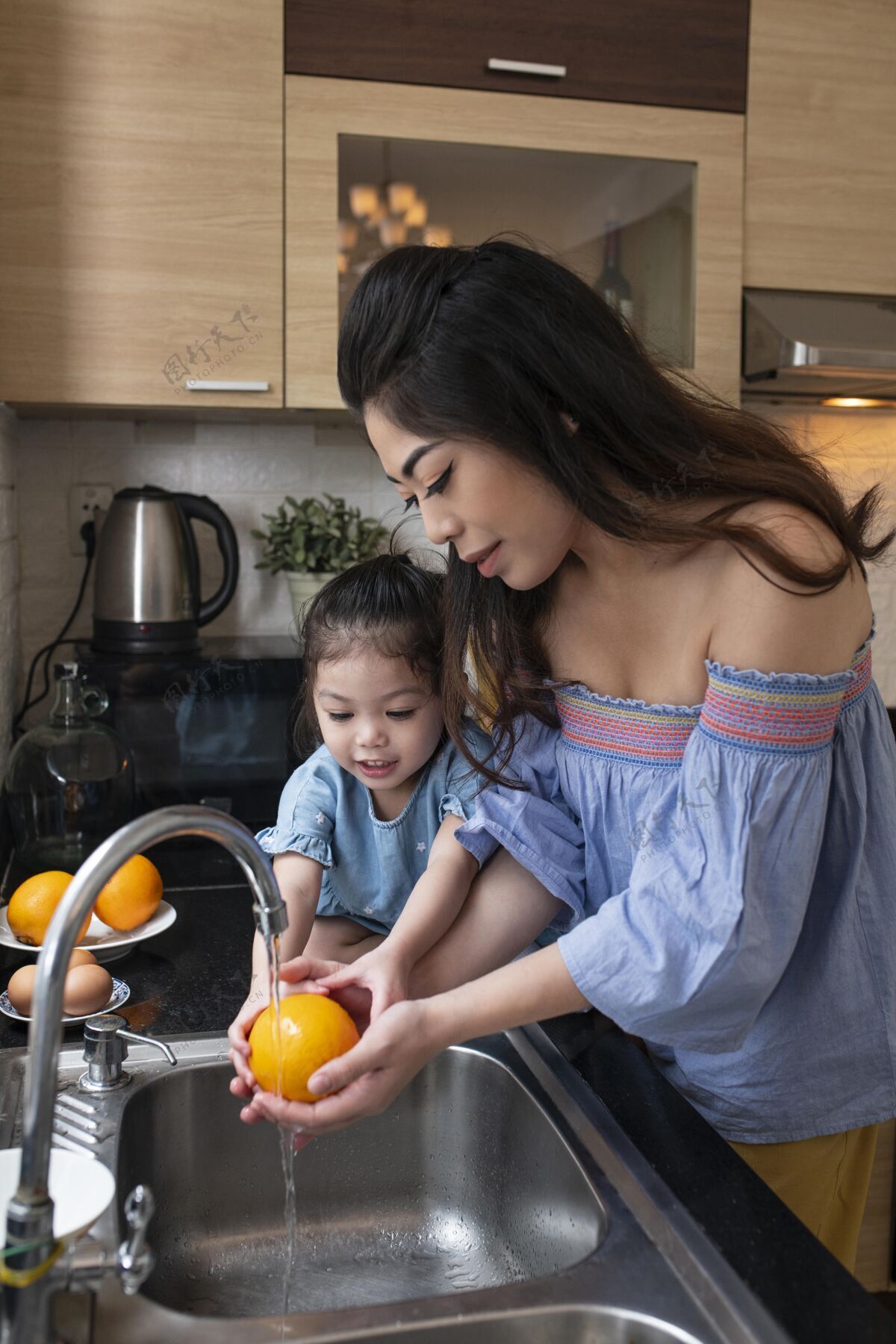 在一起中等身材的孩子和妈妈在洗橘子中镜头女孩父母