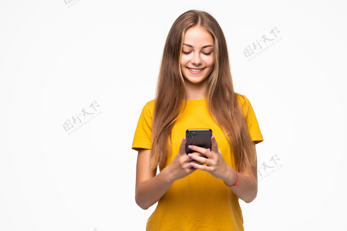 电话一位面带微笑的休闲女士在白墙上举着智能手机的画像欢呼年轻人成年人