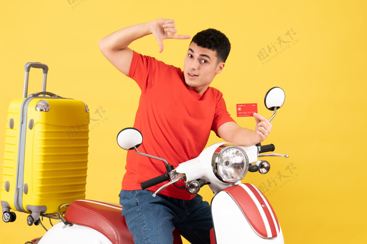 车辆前视图：骑着轻便摩托车的年轻人拿着黄色手提箱的名片微笑黄色男性