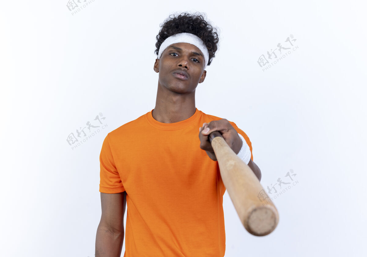 腕带自信的年轻美国黑人运动男子戴着头带和腕带拿着球棒对着镜头背景男人非裔美国人