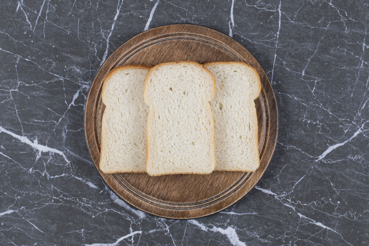 烘焙把切片面包的照片放在木砧板上新鲜晚餐饮食