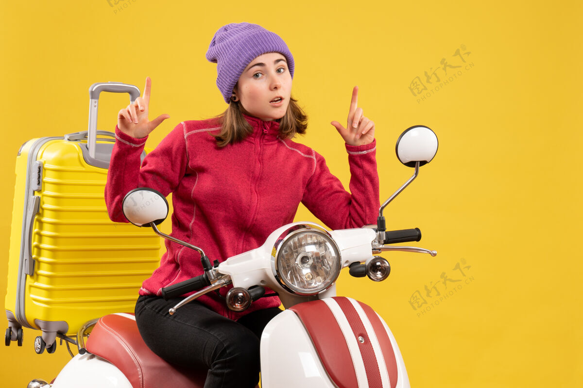 成人前视图：骑着轻便摩托车的年轻女孩用特殊的手势坐着手势前面