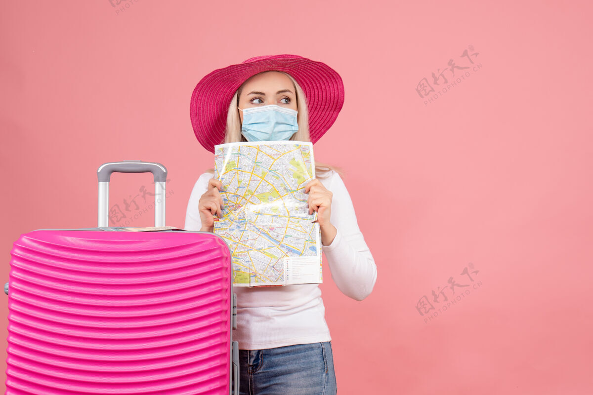 手提箱正面图漂亮的年轻女士站在手提箱旁边拿着地图站着地图快乐