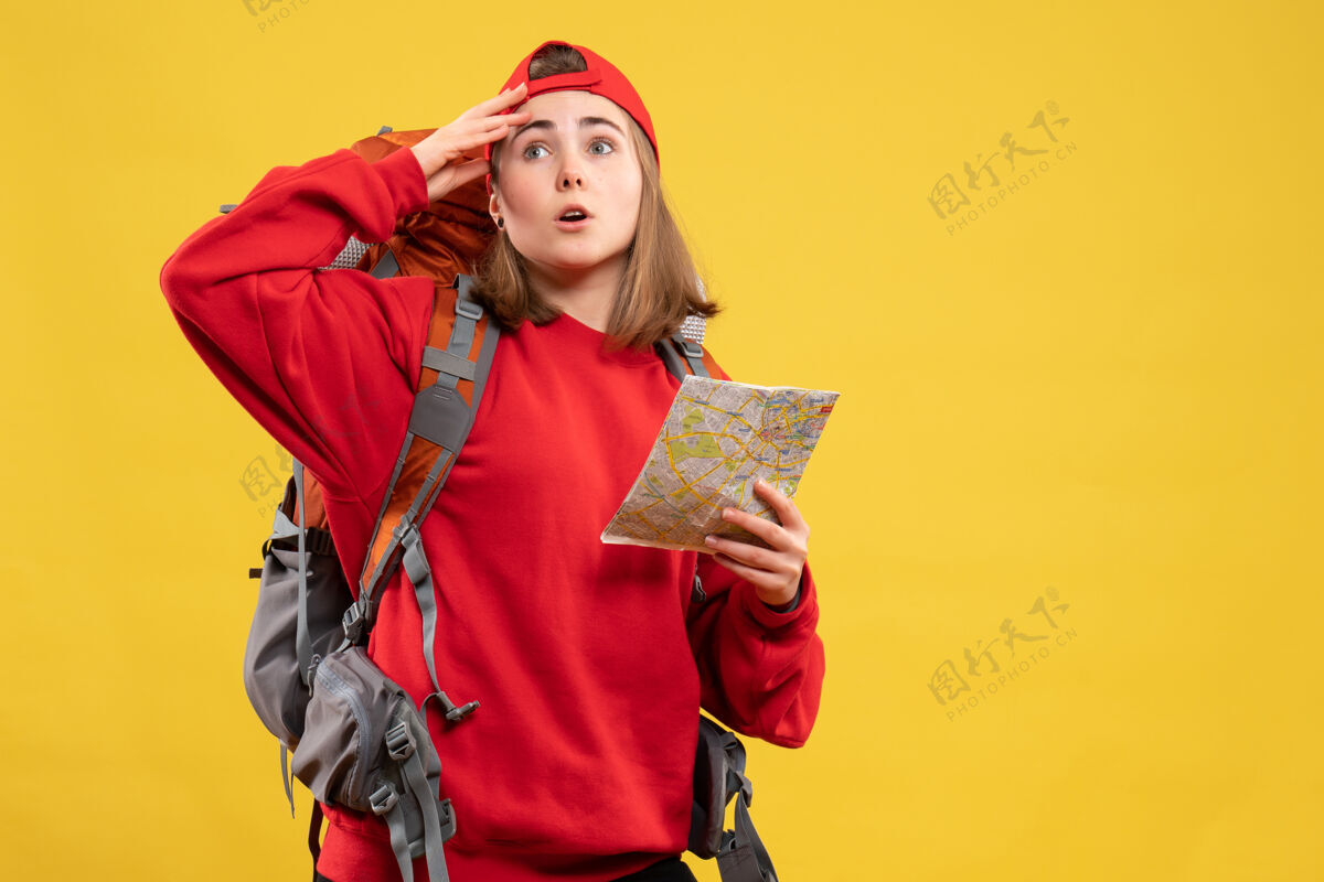 地图正面图漂亮的女旅行者背着背包拿着地图困惑混乱帽子前面