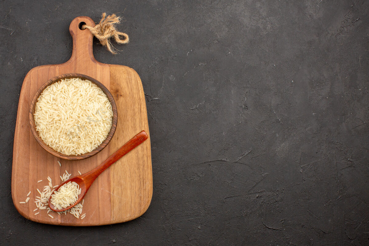 面包在灰色表面上的棕色木板内的生大米俯视图食物新鲜的健康