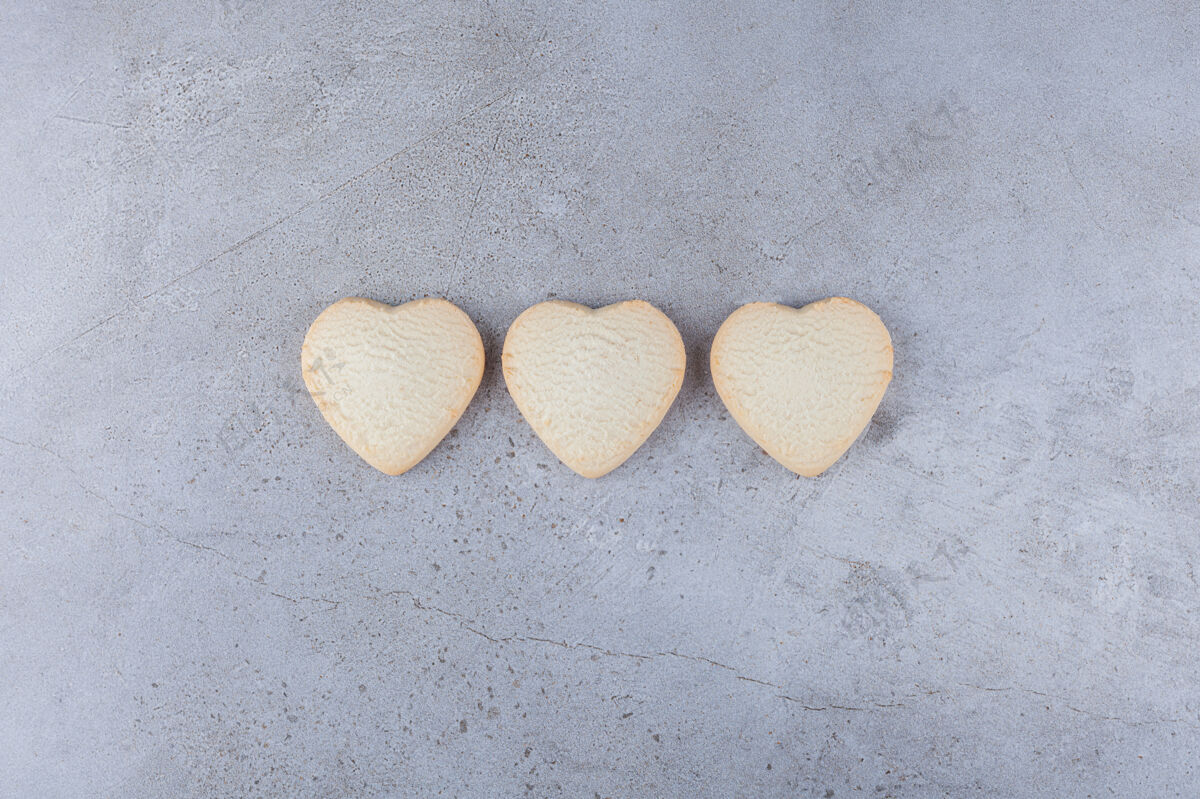 美味美味的饼干放在心形的石头桌上爱心饼干
