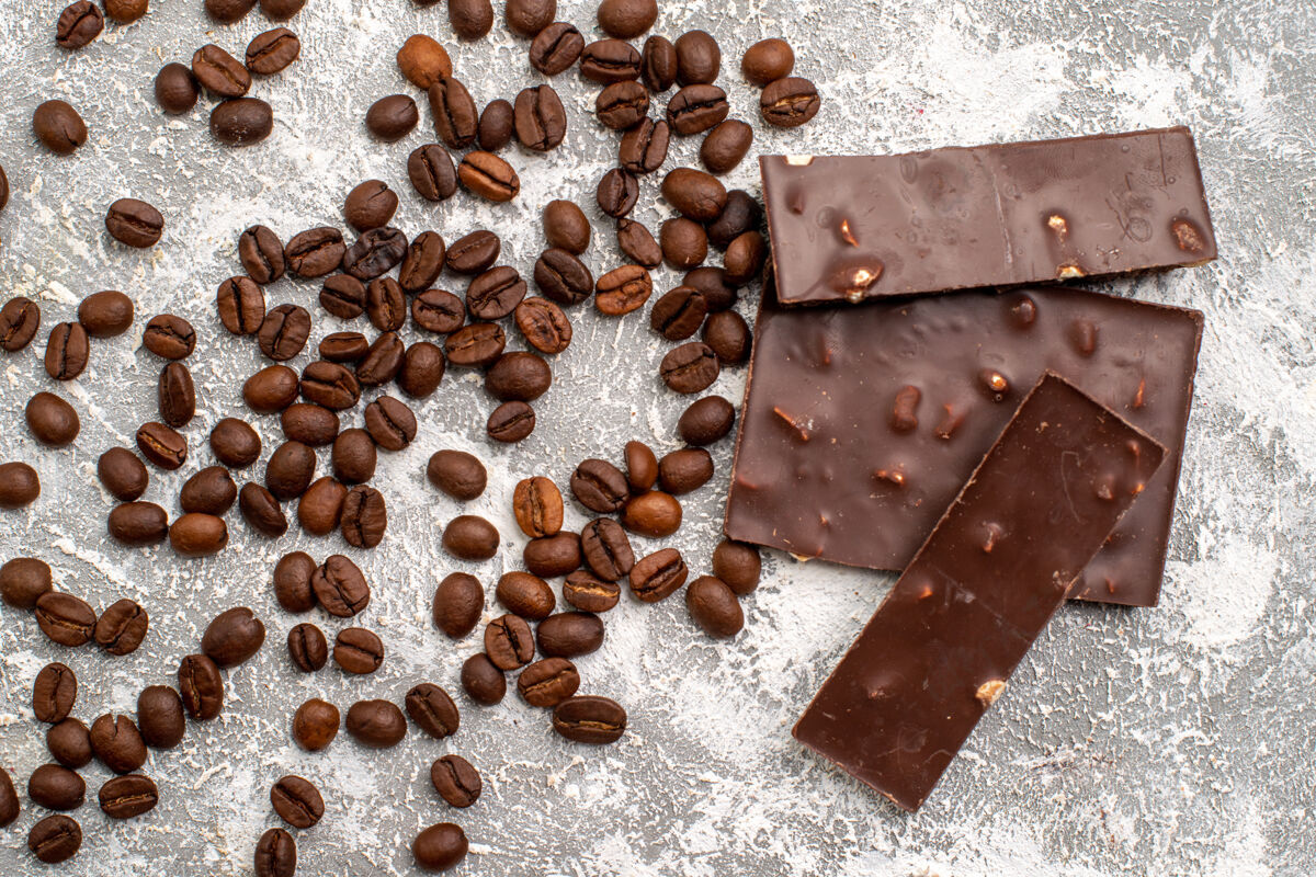 咖啡籽白色表面带有巧克力条的咖啡籽俯视图食品种子咖啡条