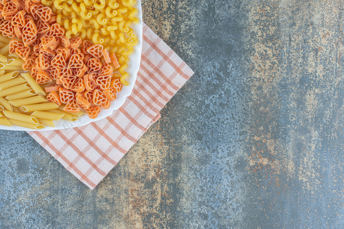 意大利面食心形 佩恩和弗西利意大利面在碗里毛巾上 大理石背景上烹饪美味佩恩面食