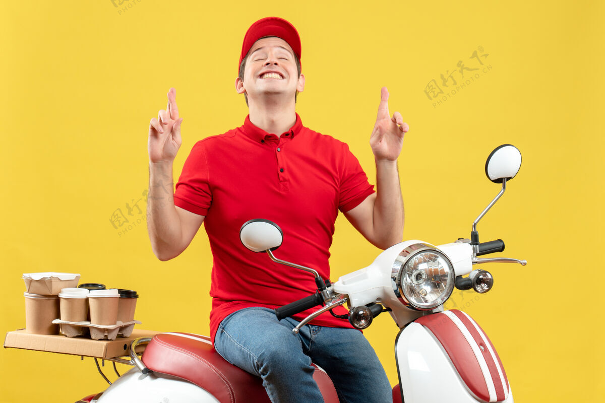 摩托车正面是一个穿着红色上衣 戴着帽子 在黄色背景上向上传递命令的快乐年轻人黄色健身背景
