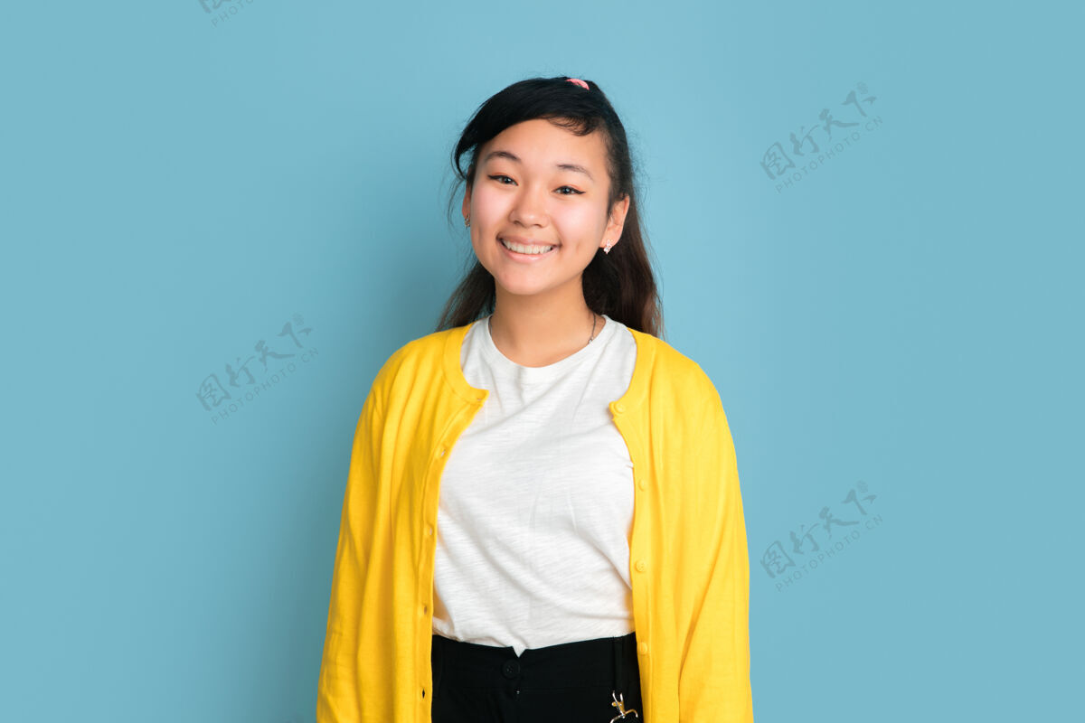 工作在蓝色工作室背景上孤立的亚洲青少年肖像美丽的深褐色女性模特 留着休闲的长发人类情感的概念 面部表情 销售 广告微笑可爱衬衫女性行政