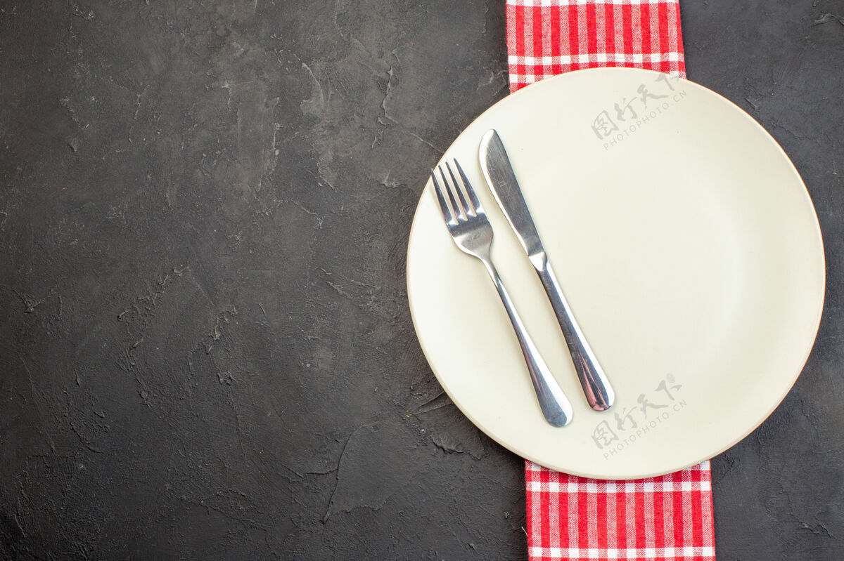 符号顶视图白色板与叉子和刀在黑暗的表面金属叉子餐具