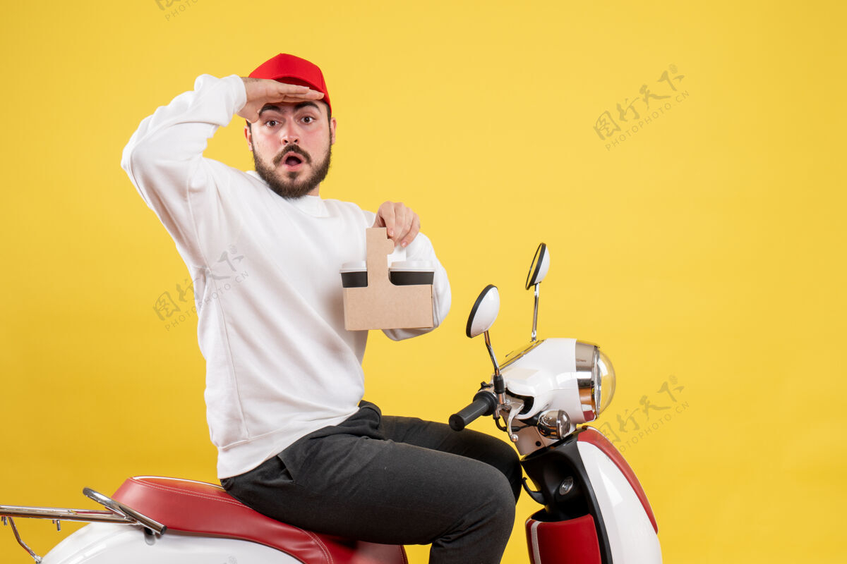 男信使前视图的男性信使举行交付咖啡看黄色的墙壁摩托车服务工作