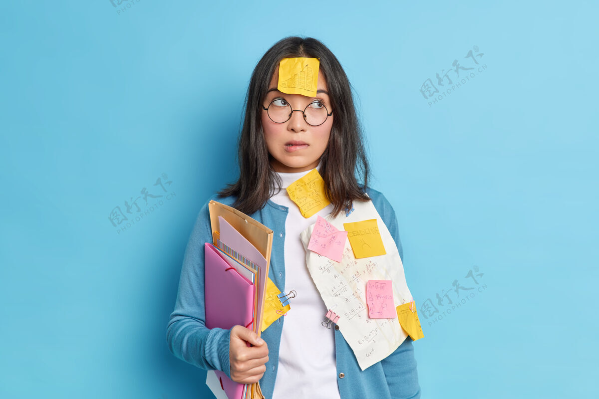姿势沉思迷惑不解的女生在学校备考咬着嘴唇 聚精会神地试着在数学考试前学习信息戴着圆眼镜矫正视力工作房子沉思
