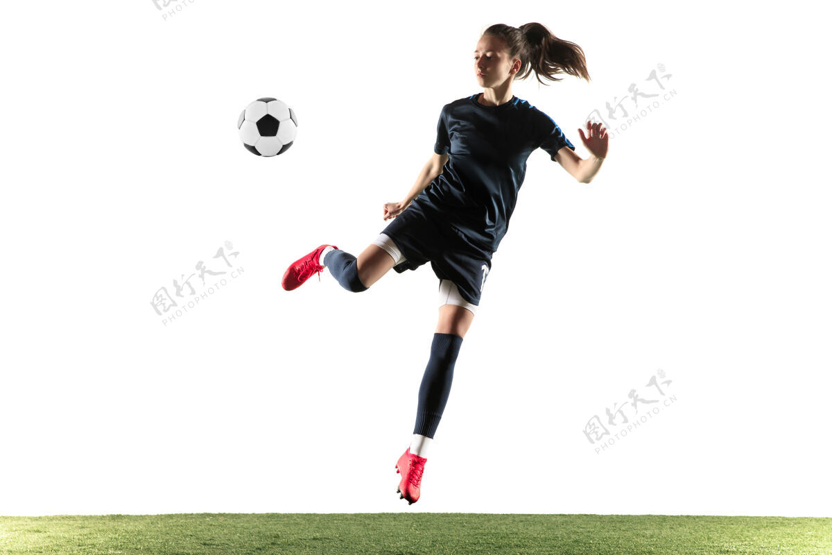 姿势年轻的女性足球运动员或足球运动员 长发 运动服和靴子 在白色背景上为目标踢球健康的生活方式 职业体育 爱好的概念玩球员运动