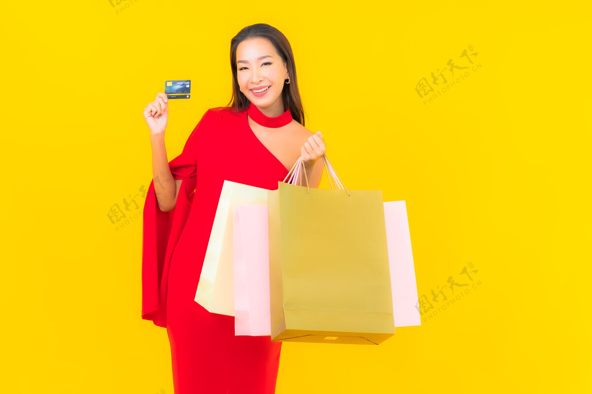 人带购物袋和信用卡的美丽亚洲年轻女子肖像销售多彩买家