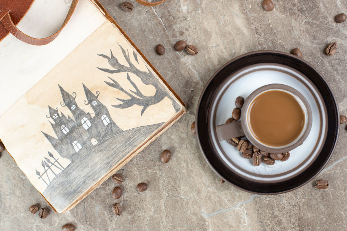 香味咖啡杯 咖啡豆和笔记本放在大理石表面咖啡因配料烤