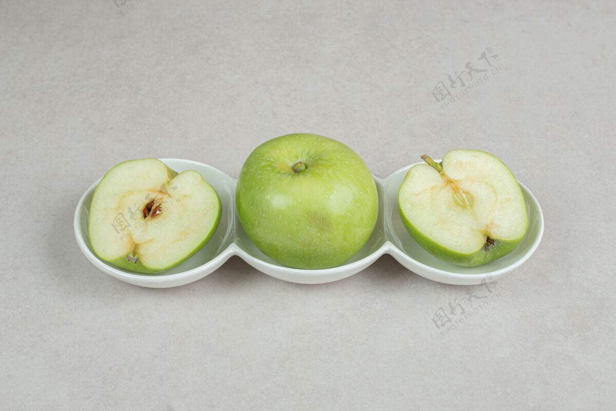 生的全切半切的青苹果放在白碗里新鲜有机美味