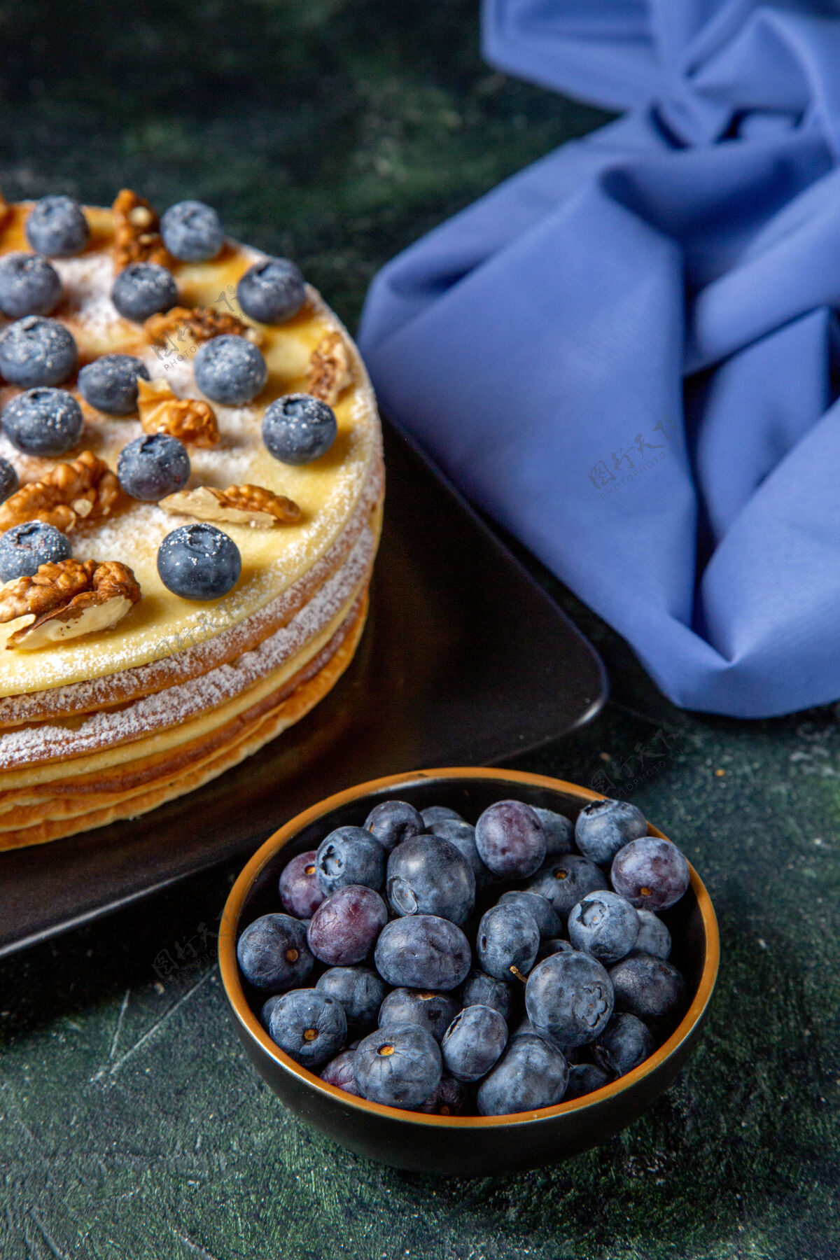 甜点前视图美味的蜂蜜蛋糕与蓝莓和核桃内板黑暗的表面深色核桃水果