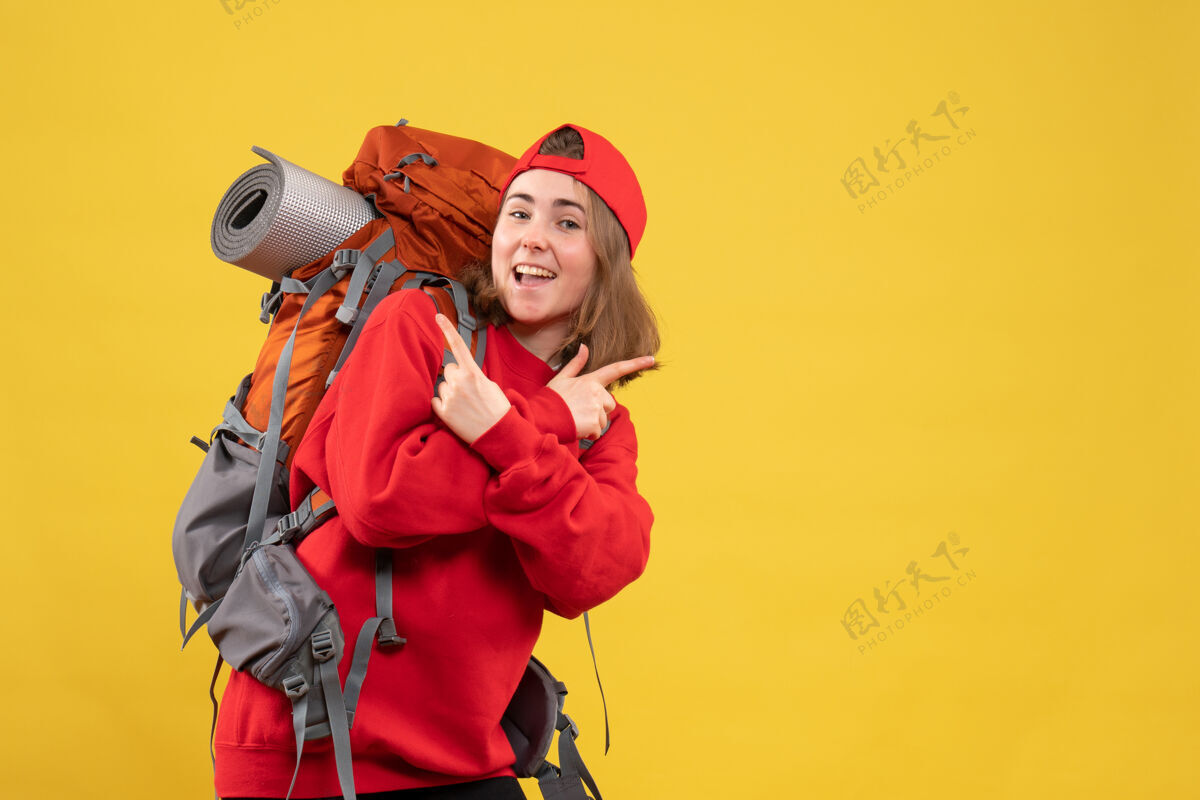 前面正面图：穿着红色背包的快乐旅行者女士双手交叉成人人人