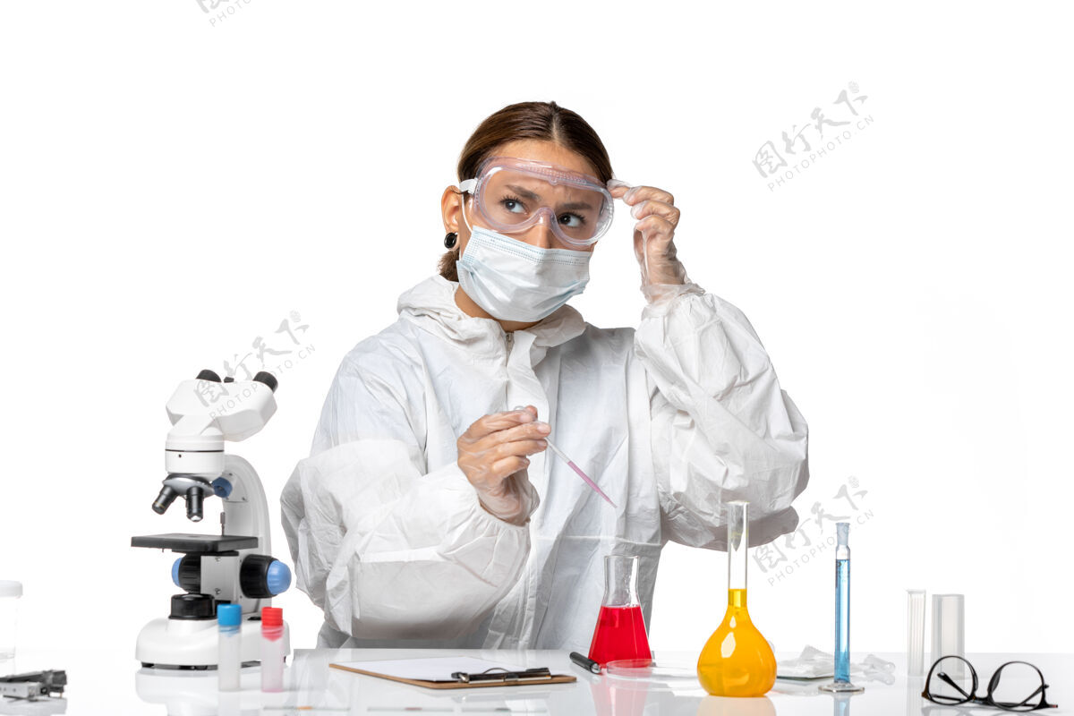 人前视图穿着防护服 戴着口罩的女医生正在研究解决方案 思考白色背景的冠状病毒大流行视野大流行套装