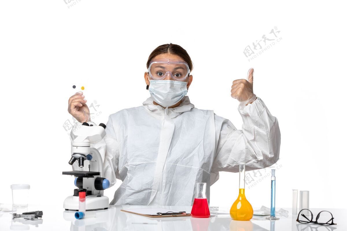 医生正面图女医生穿着防护服 戴着口罩拿着样品 背景是淡白色的医药卫生大流行病毒冠状病毒防护女医生外套