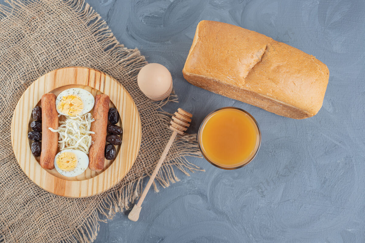 美味早餐盘上放着果汁和面包 放在大理石桌上橄榄蜜匙面包