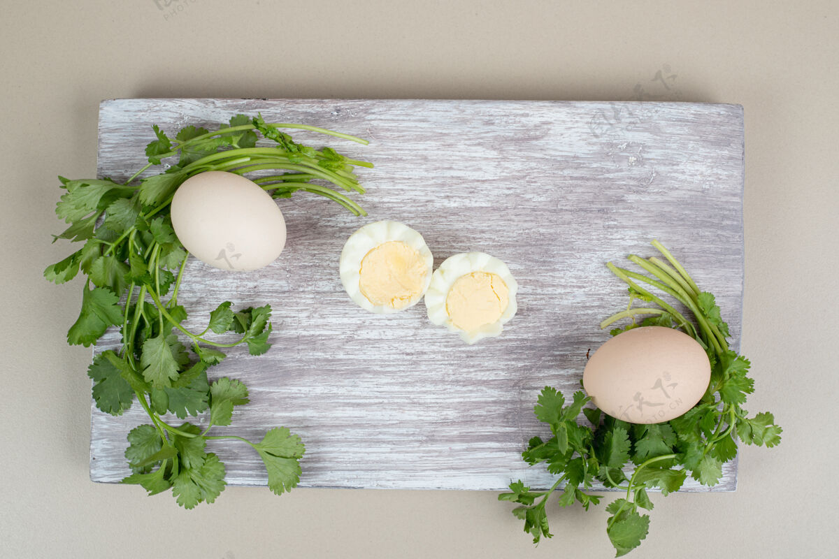 鸡蛋木砧板上的煮鸡蛋和生鸡蛋生的绿色生的