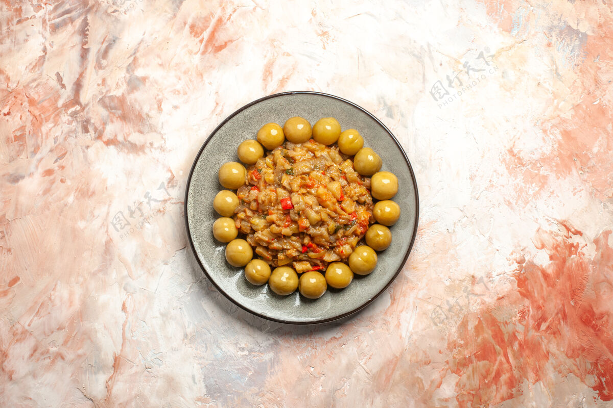 健康烤茄子沙拉和腌李子在裸体表面上的盘子俯视图种子茄子沙拉谷物