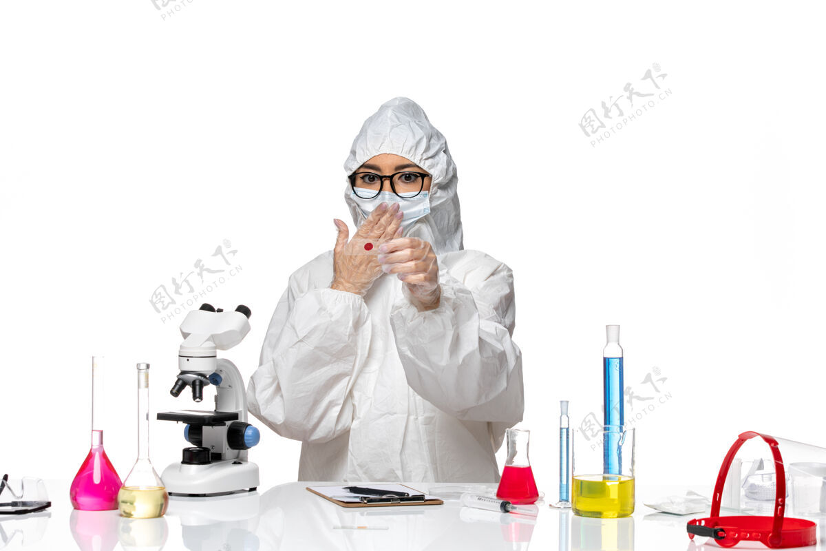 医生正面图身着特殊防护服的女化学家在白色办公桌上用显微镜检查样本病毒化学冠状病毒-大流行健康化学病毒大流行