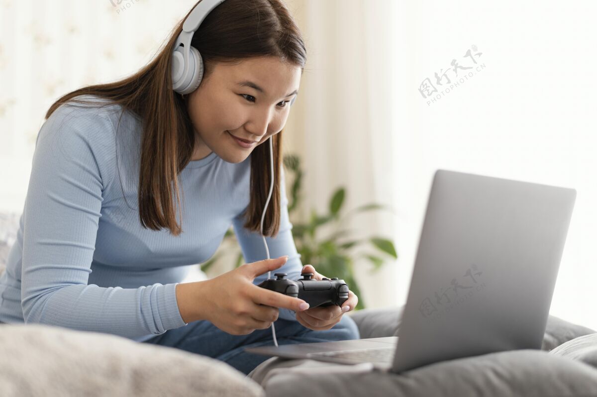休闲在笔记本电脑上玩电子游戏的女孩设备全拍摄玩