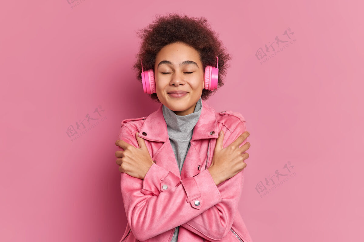 人一头非洲卷发的可爱女孩闭上眼睛拥抱自己听音乐情绪姿势非洲