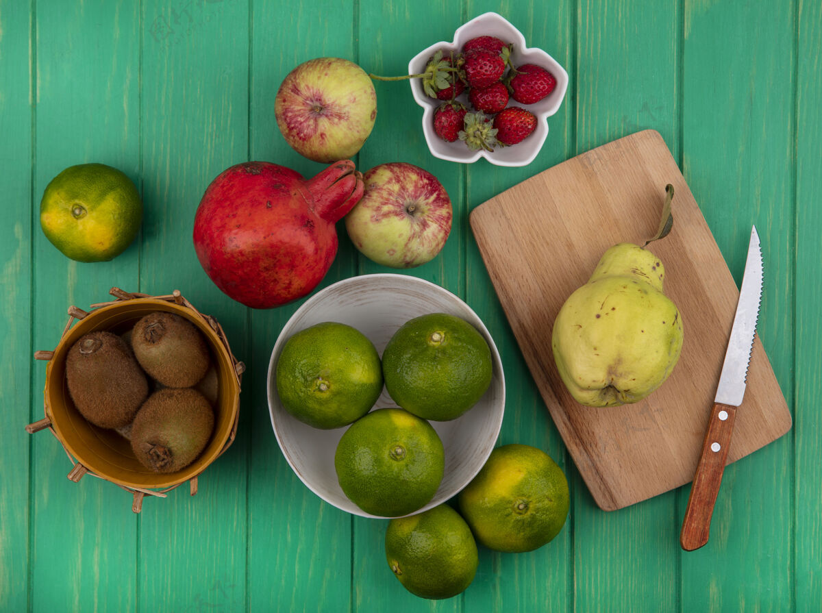 绿色顶视图橘子在碗里与猕猴桃苹果石榴和梨在砧板上观点橘子食物