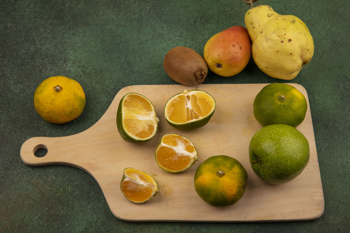 景观新鲜的橘子在木制厨房板上的俯视图 橘木瓜和梨被隔离了绿色柑橘木材