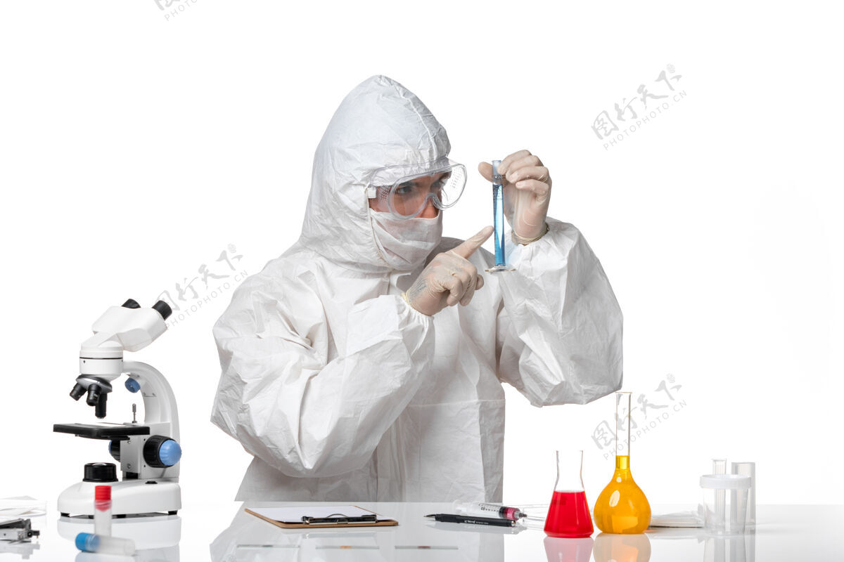 病毒正面图：男医生穿着防护服 戴着面罩 因为在空白处有蓝色溶液的瓶子健康男人蓝色
